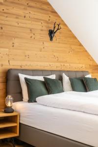 a bedroom with a large bed with a wooden wall at Apartments Am Dorfplatzl in Hohentauern