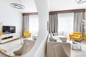 een woonkamer met witte meubels en gele stoelen bij Silkhaus Luxurious Pool & Gym 1BDR Art Residence in Dubai