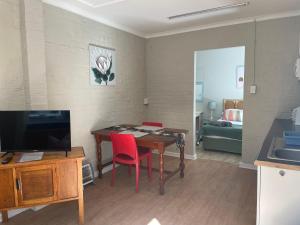 a living room with a dining room table and a television at Wedmore Place in Grahamstown