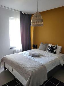 Schlafzimmer mit einem großen weißen Bett und einem Fenster in der Unterkunft Appartement en plein centre de mons in Mons