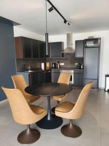 eine Küche mit einem Tisch und Stühlen in der Unterkunft Appartement en plein centre de mons in Mons