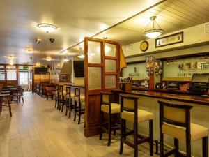 um restaurante com um bar com cadeiras e mesas em Tudor House Guest House em Dungarvan
