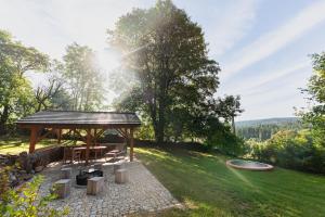 cenador con mesa y sillas en un patio en Moderní šumavská roubenka s výhledem na Boubín, en Vimperk