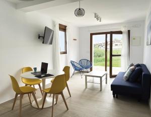 Apartamentos El Camino Resorts في كوبرسيز: غرفة معيشة مع طاولة وكراسي وأريكة