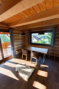 een eetkamer met een tafel en stoelen en een raam bij Moderní šumavská roubenka s výhledem na Boubín in Vimperk