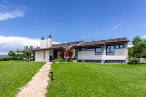 une maison avec une pelouse verte devant elle dans l'établissement Villa Roccolo, à Calmasino