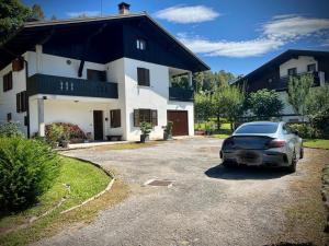 a car parked in a parking lot in front of a house at Casa Pura in Ampezzo