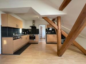 a large kitchen with wooden cabinets and a staircase at Sauwohlfühlhof - Ferienhof Winkelkötter in Everswinkel
