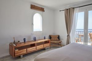 a bedroom with a bed and a desk with a window at Casa Sierra - Mijas Pueblo in Mijas