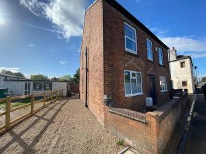 a brick building with a fence next to it at Silver Stag Properties, Ensuite Bedrooms w Kitchen in Swadlincote