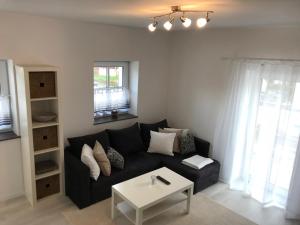 a living room with a black couch and a table at Wohnung mit eigenem Zugang in Hochdorf