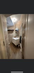 y baño con lavabo blanco y espejo. en Chambre 7 kitchenette Les gites de la Gare, en Mussidan