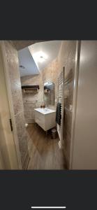 a bathroom with a white sink and a mirror at Chambre 7 kitchenette Les gites de la Gare in Mussidan