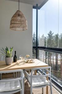 une salle à manger avec une table et deux chaises blanches dans l'établissement Valoisa pikkukaksio Golf-kentän ja järven vieressä, à Kirkkonummi