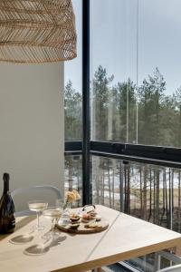 uma mesa com pratos de comida e copos de vinho em Valoisa pikkukaksio Golf-kentän ja järven vieressä em Kirkkonummi