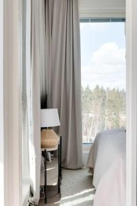- une chambre avec un lit et une fenêtre dans l'établissement Valoisa pikkukaksio Golf-kentän ja järven vieressä, à Kirkkonummi