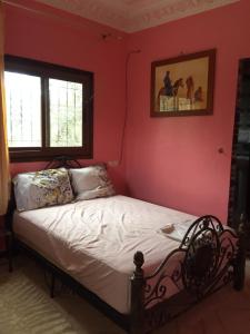 - une chambre dotée d'un lit avec un mur rose dans l'établissement Villa SLS privé avec piscine privée, à Ourika