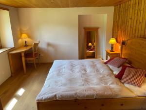 a bedroom with a large bed and a desk at Weissmies Lodge in Saas-Grund