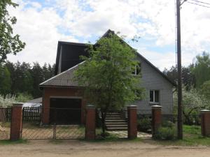 a house with a fence in front of it at Cozy apartment near the airport in Rīga