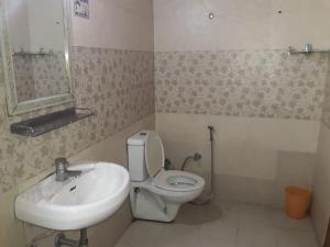 a bathroom with a white toilet and a sink at StayApart I The Maple Residences - Lake Front in Nainital