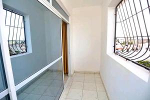 a hallway with two windows and a tiled floor at Lux Suites Ratna Furnished Apartments in Mombasa