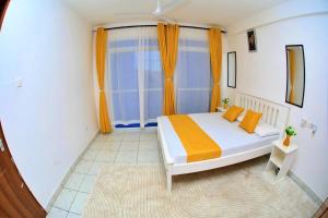 a bedroom with a bed and a large window at Lux Suites Ratna Furnished Apartments in Mombasa