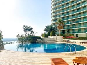 a swimming pool in front of a large building at Beach Towers A, Reem Island Abu Dhabi - Mint Stay in Abu Dhabi