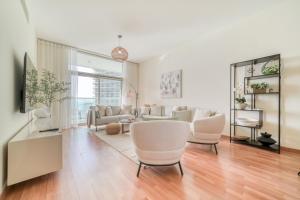 a living room with white furniture and a large window at Beach Towers A, Reem Island Abu Dhabi - Mint Stay in Abu Dhabi