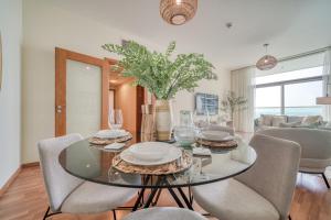 uma sala de jantar com uma mesa de vidro e cadeiras em Beach Towers A, Reem Island Abu Dhabi - Mint Stay em Abu Dhabi