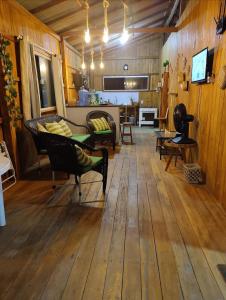 een woonkamer met houten vloeren en een bank en stoelen bij Maresia Beach in Ajuruteua