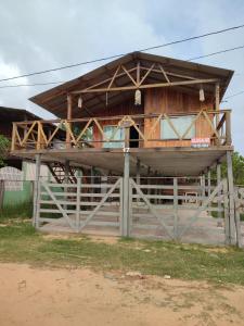 ein Holzgebäude mit einem Zaun davor in der Unterkunft Maresia Beach in Ajuruteua