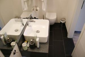 a bathroom with a white sink and a toilet at Messe- und Gästezimmer Hildesheim in Harsum