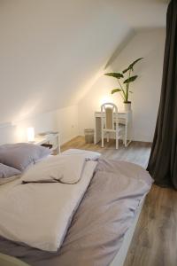 a bed in a room with a table and a plant at Messe- und Gästezimmer Hildesheim in Harsum