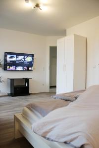 um quarto com uma cama e uma televisão de ecrã plano em Messe- und Gästezimmer Hildesheim em Harsum