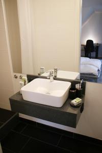 y baño con lavabo blanco y espejo. en Messe- und Gästezimmer Hildesheim en Harsum