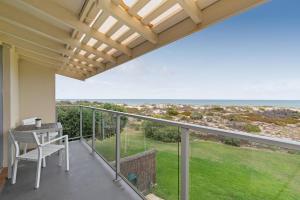 Un balcón con mesa y vista al mar. en THE SHORE- Absolute beachfront holiday house, en Port Adelaide