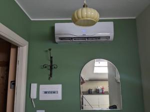 a room with a green wall with a mirror and a heater at la nocciolina mansarda in centro in Cortemilia