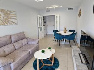 ein Wohnzimmer mit einem Sofa, Tischen und Stühlen in der Unterkunft Gemelos24 Benidorm La Cala beach 200m in Benidorm