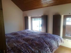 a bedroom with a bed and two windows at Beiral da Marfida in Amarante
