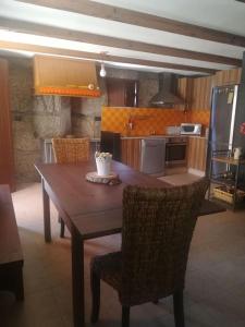 cocina con mesa de madera y sillas en una habitación en Beiral da Marfida, en Amarante