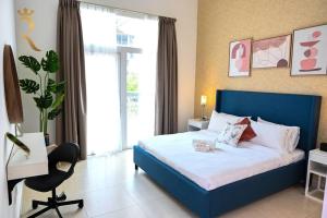 a bedroom with a blue bed and a desk and a chair at 1BR Oasis at Starry Yas Supernova Apartment in Abu Dhabi