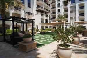 un patio de un edificio con plantas y árboles en 1BR Oasis at Starry Yas Supernova Apartment, en Abu Dabi
