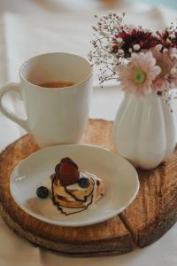 una taza de café y un plato de comida en una mesa en Haus Koinonia, 