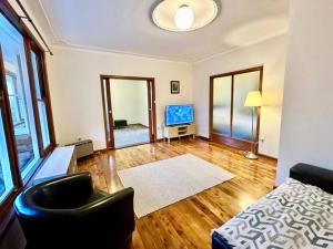 a living room with a couch a chair and a television at Mount St. Raphael's in Leura