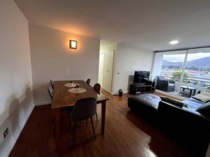 un soggiorno con tavolo e divano di Cozy Apartment Near Airport, Secure, and Versatile a La Serena
