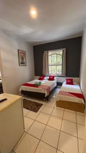 a bedroom with two beds and a window at Hotel Guarany da Serra in Poços de Caldas