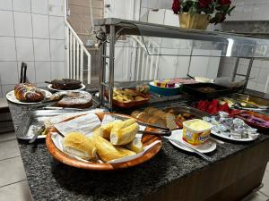 a buffet with a bunch of food on a counter at Hotel Guarany da Serra in Poços de Caldas