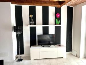 a living room with a tv and black and white stripes at Garden House Soave in Soave