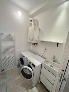 een badkamer met een wasmachine en een wastafel bij Garden House Soave in Soave