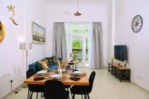 una sala da pranzo e un soggiorno con tavolo e sedie. di 1BR Oasis at Starry Yas Supernova Apartment a Abu Dhabi